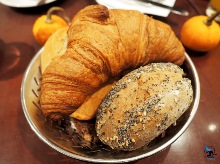 Basket of bread, including croissant and Brötchen.
